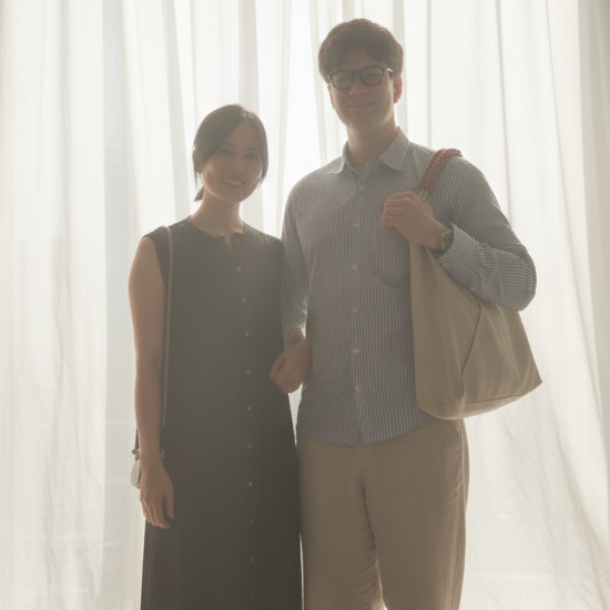 Two people standing in front of a large window with sheer curtains. On the left Haruka co-founder of TBD°; on the right Lasse , co-founder of TBD°